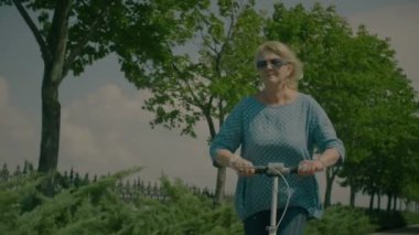 Yaşlı kadının onun scooter binmek doğada