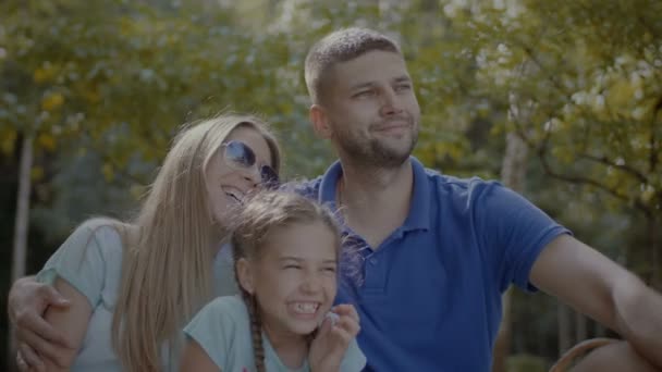 Strahlende Familie mit Tochter entspannt im Park — Stockvideo