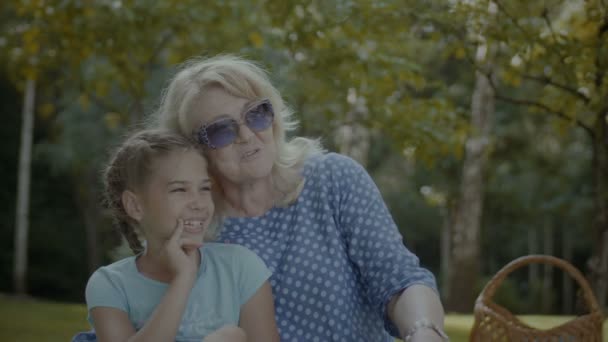 Χαμογελαστός γιαγιά μιλώντας με χαριτωμένο κορίτσι στο πάρκο — Αρχείο Βίντεο