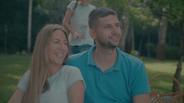 Filha alegre abraçando pais sorridentes ao ar livre — Vídeo de Stock