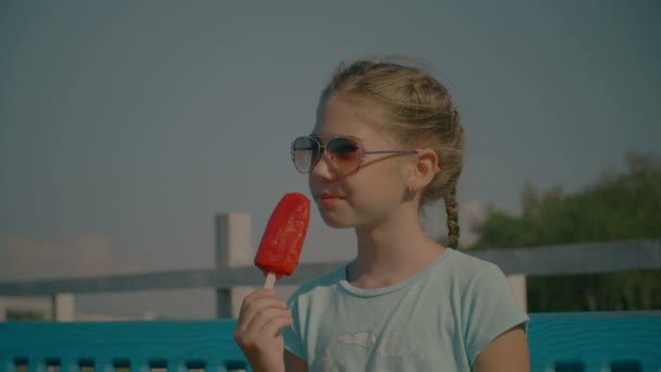 Joyful cute girl eating fruit ice cream in summer — Stock Video