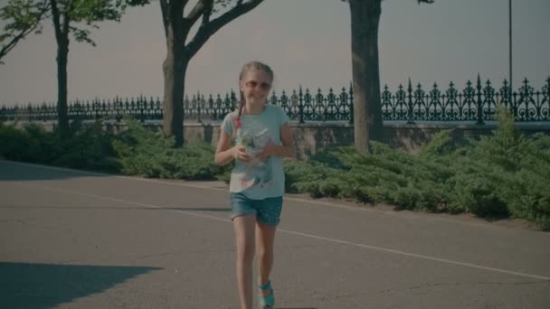 Excited adorable girl carrying ice creams in park — Stock Video