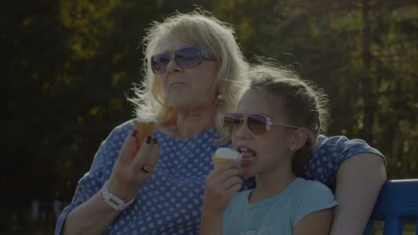 Niño comiendo helado con la abuela al aire libre — Vídeo de stock