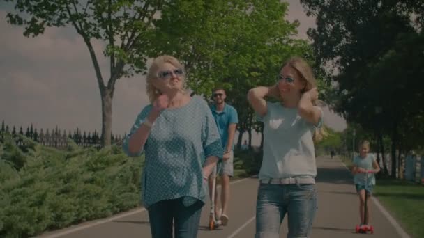 Семья трех поколений отдыхает в летнем парке — стоковое видео