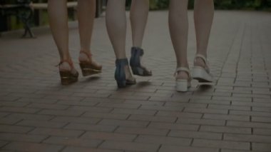 Arnavut kaldırımlı kaldırımda yürüyen ince kadın bacakları