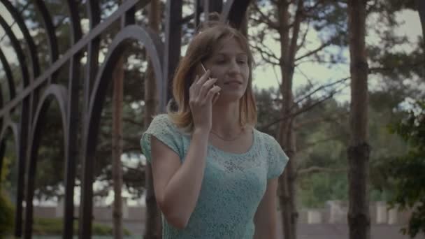 Ragazza carina occupata con il cellulare che cammina all'aperto — Video Stock