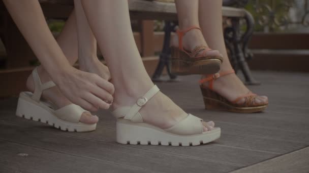 Женские руки прикрепляют пластырь на каблуке — стоковое видео