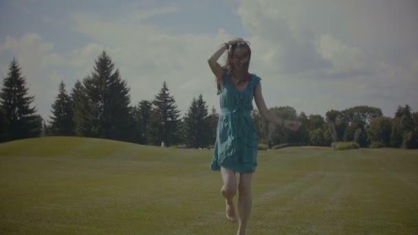 Беззаботная босиком женщина бегает по зеленому полю — стоковое видео