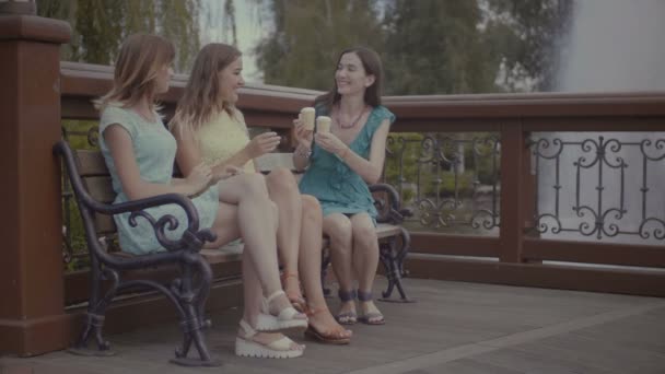 Tři krásné přítelkyně jíst zmrzlinu na lavičce