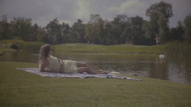 Elegante hübsche Frau ruht sich im Sommerpark aus — Stockvideo