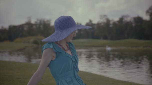 Portret van charmante meisje in zon hoed rusten in de buurt van lake — Stockvideo