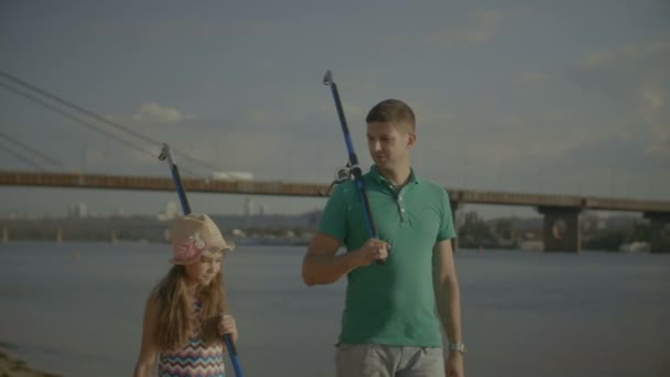 Balıkçılık çubuklar taşıyan sevimli kızıyla babası — Stok video