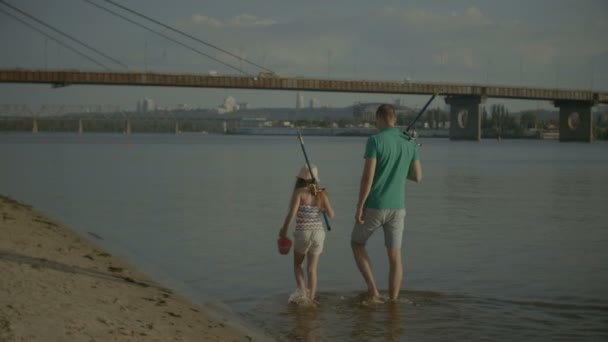 Familia con cañas de pescar caminando a orillas del río — Vídeos de Stock