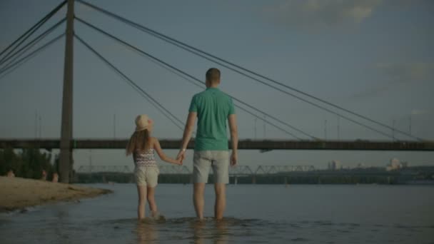 Счастливая семья наслаждается выходными на берегу реки — стоковое видео