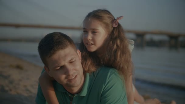 Щаслива сім'я в чаті відпочиває на літньому пляжі — стокове відео