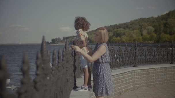 Мати з милою маленькою дівчинкою насолоджується видом на море — стокове відео