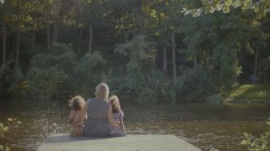 Mutlu aile göl tarafından iskelede dinlenme aşk kucaklama içinde