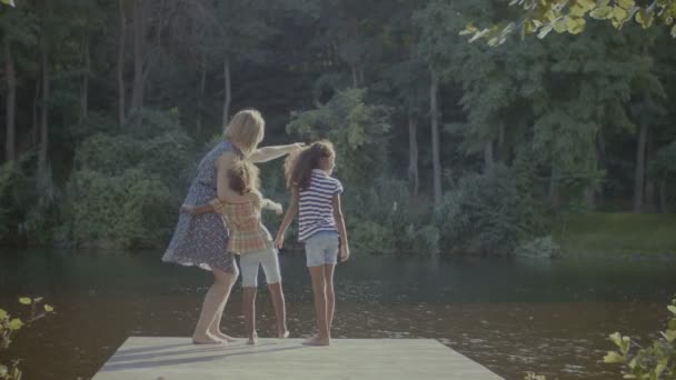 Diversa famiglia in piedi sul molo di legno vicino al lago — Video Stock