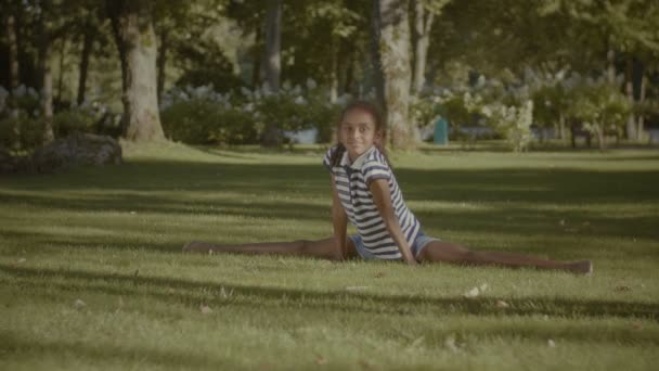 Χαριτωμένο μικρό κορίτσι που εκτείνεται στα πόδια, κάνει το χωρίζει — Αρχείο Βίντεο