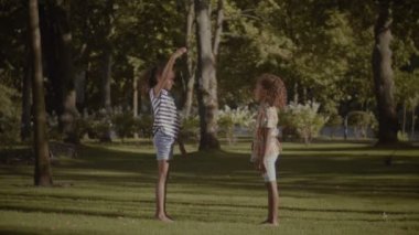 Yüksek beş açık havada veren iki gülümseyen küçük kız