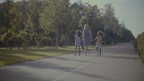Ποικιλόμορφη οικογένεια με παιδιά με έναν περίπατο στο πάρκο — Αρχείο Βίντεο