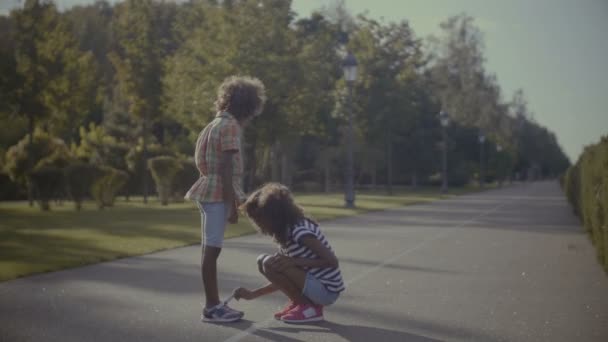 Κοριτσάκι βοηθώντας νεώτερη αδελφή να δεσμεύσουμε παπούτσια — Αρχείο Βίντεο
