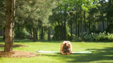 Uygun kadının açık havada germe pilates egzersizleri yapması