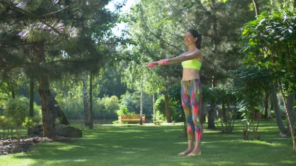 Lachende fitness vrouw uit te werken met halters — Stockvideo