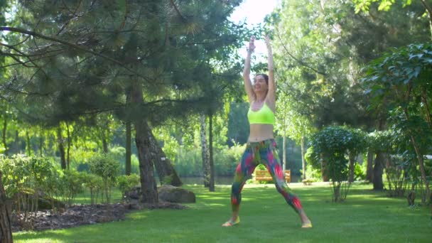 Mujer activa haciendo ejercicio de fitness sobre hierba verde — Vídeos de Stock