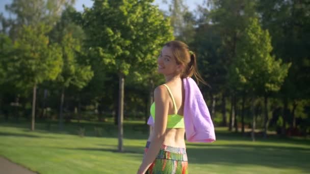 Donna in forma sottile che cammina lungo il parco dopo aver fatto jogging — Video Stock