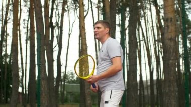 Amatör erkek tenis oyuncu spor tenis maçı açık havada oynarken hardcourt üzerinde forehand topa vuruyor. Bir etkin yaz yaşam tarzı yaşayan spor oyun fitness yaşam tarzı insan. Slo mo.
