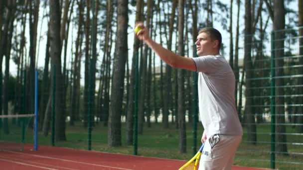 Jugador de tenis preparándose para servir una pelota en la cancha — Vídeo de stock