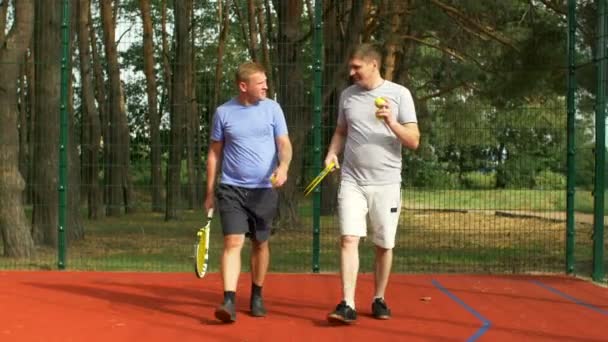 Jugadores de tenis alegres que van a la cancha de tenis — Vídeos de Stock