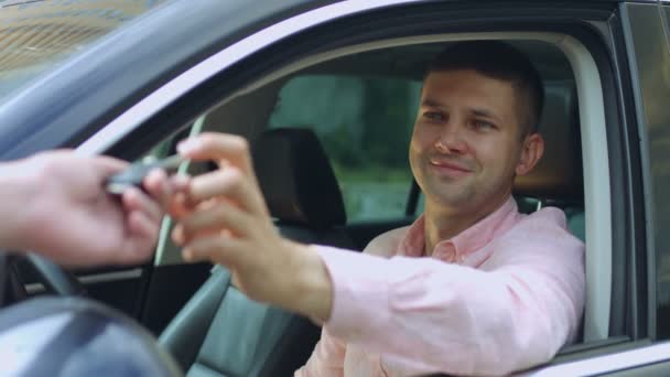 Vendedor de coches dando la llave al dueño del coche nuevo — Vídeos de Stock