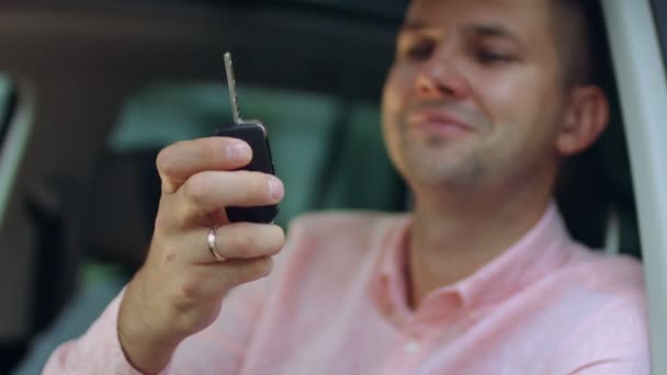 Mano masculina sosteniendo las llaves del coche del vehículo nuevo — Vídeos de Stock