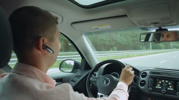 Αντανάκλαση στο κάτοπτρο οδηγήσεως του άνδρα οδήγηση αυτοκινήτου — Αρχείο Βίντεο