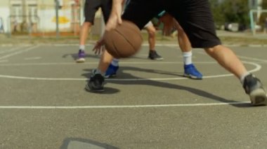 Genç adam basketbol sahasında top ile top sürme