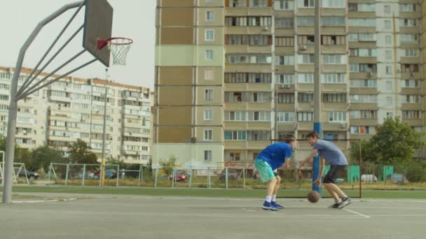 Streetball player taking jump shot on basketball court — Stock Video