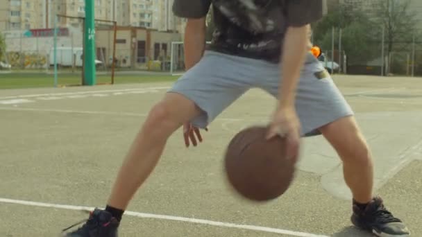 Streetball mężczyzn gracz odbijając piłkę na boisko — Wideo stockowe