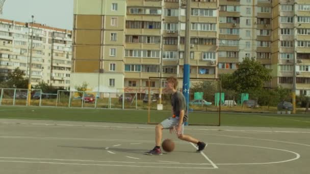 Jogador de basquete driblando a bola entre as pernas — Vídeo de Stock