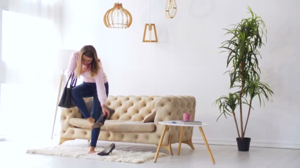 Femme enlevant des chaussures à talons hauts après le travail à la maison — Video