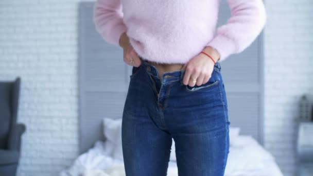 Vuxen kvinna försöker zip upp snäva jeans hemma — Stockvideo