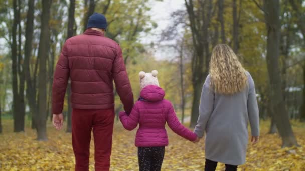 Szczęśliwa rodzina schodząc w dół drogi w jesień natura — Wideo stockowe