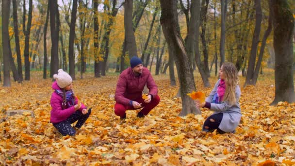 Familia positiva con chica disfrutando de la temporada de otoño — Vídeo de stock