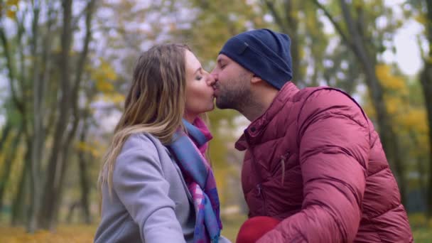 Aanhankelijk paar in tedere kus in herfst park — Stockvideo