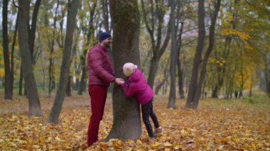 Neşeli baba ve çocuğun oynuyordu sonbaharda saklambaç
