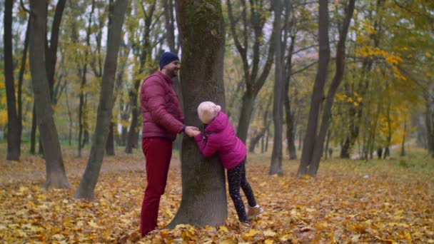 Radostné otce a dítě hraje na schovávanou na podzim — Stock video