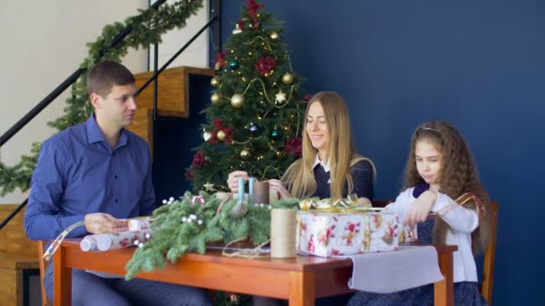 Cheerful famiy wrapping Christmas gifts at home — Stock Video