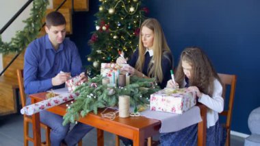 Aile Noel arifesinde Noel hediye kutuları imzalama