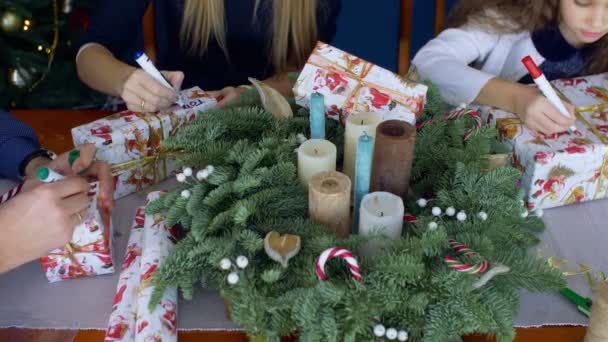 Menschenhände schreiben Namen auf Weihnachtsgeschenke — Stockvideo